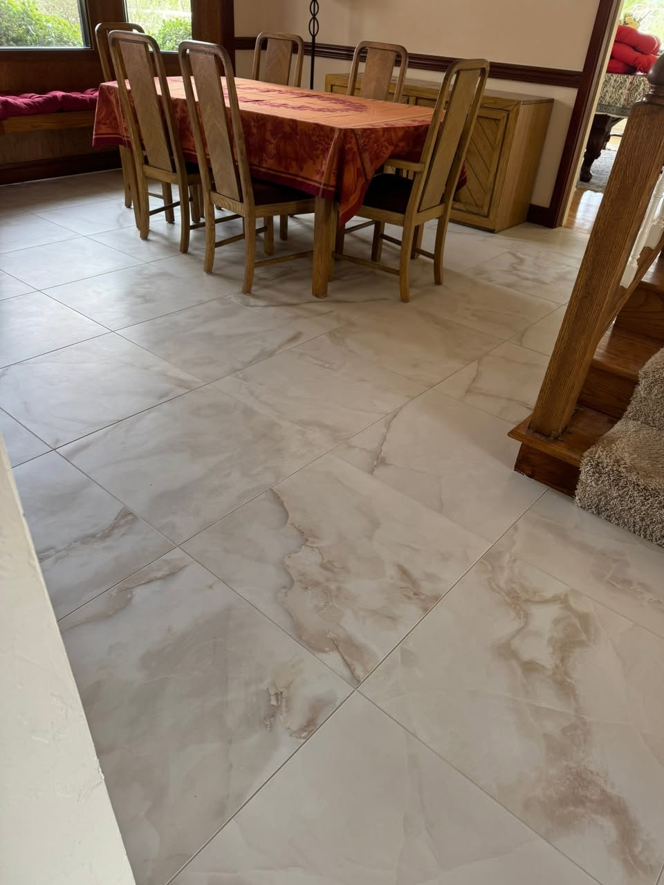 Marble-look porcelain tile floor in dining room with diagonal layout