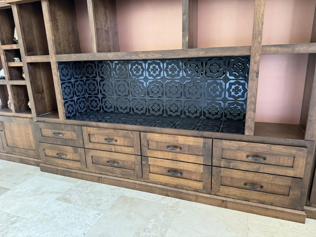 Glossy black decorative star-pattern tile backsplash on a custom wood built-in