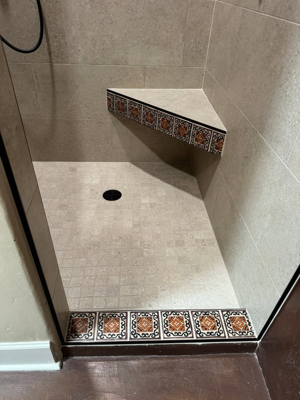 Custom shower floor with decorative Talavera border tile and corner bench
